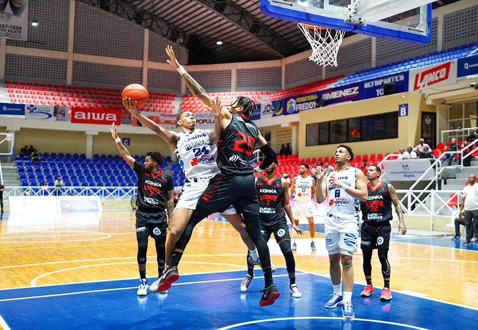 Jonathan Bello de Marineros intenta anotar sobre la defensa de los Leones